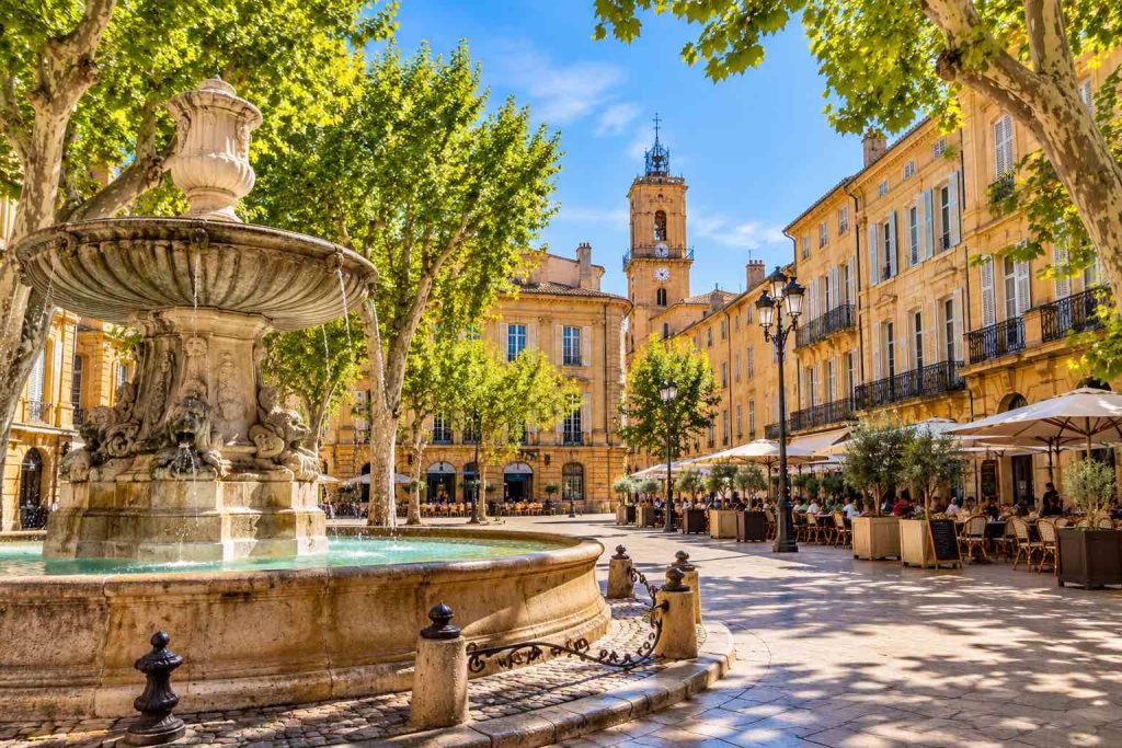 Illustration d'Aix-en-Provence avec ses façades provençales, ses platanes et ses terrasses de café – VTC Marseille Aix-en-Provence.